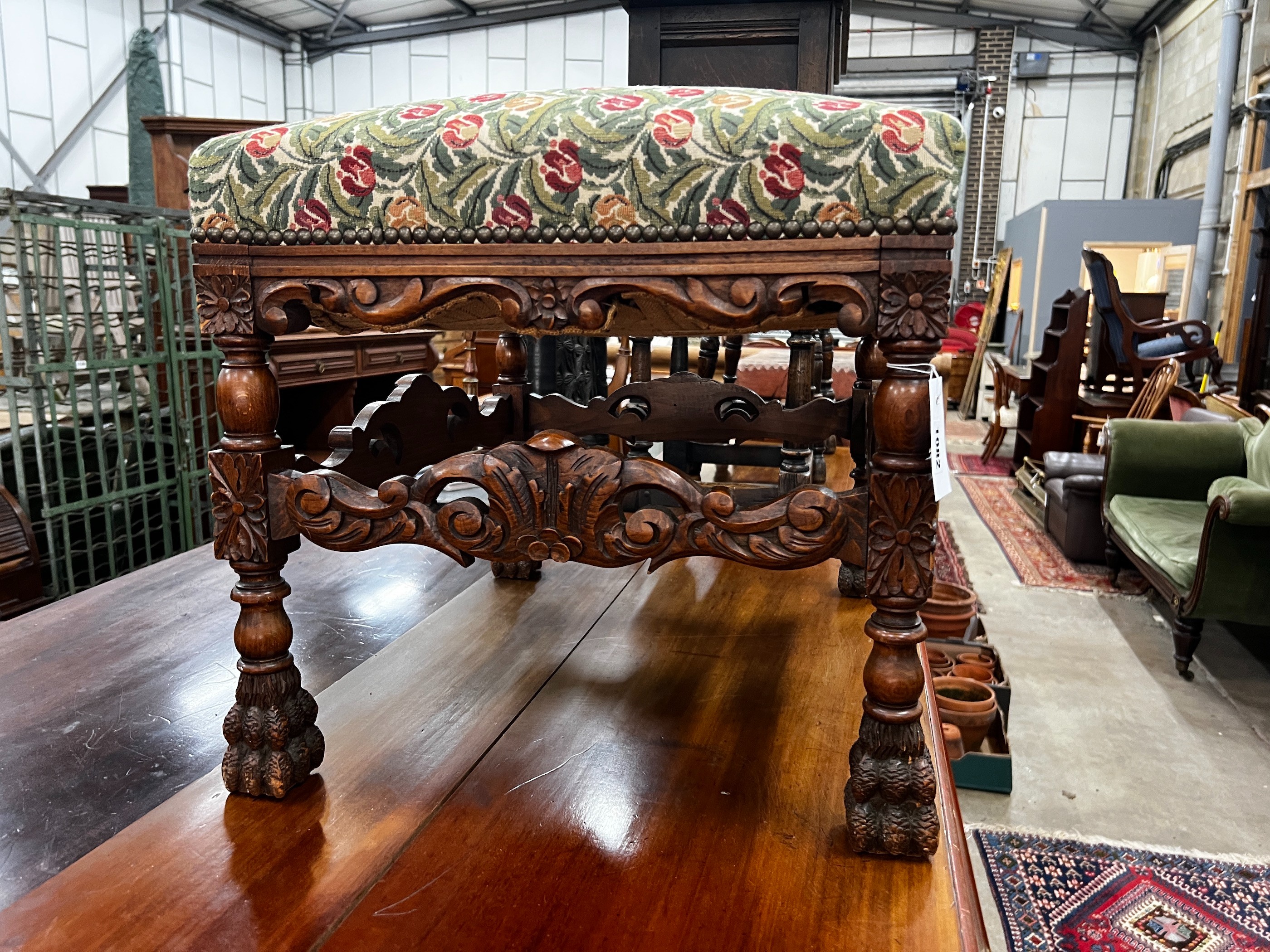 An early 20th century Jacobean revival carved beech dressing stool, length 60cm, depth 48cm, height 49cm